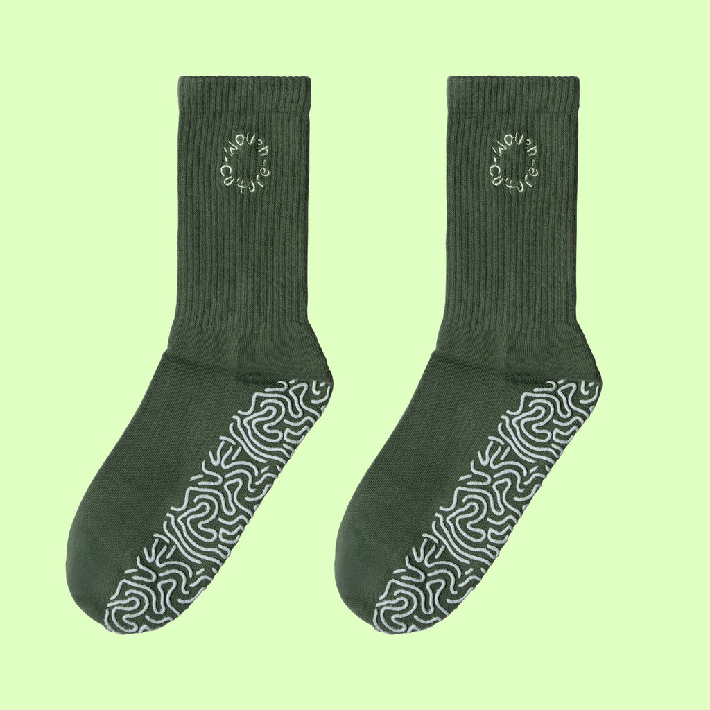 Pair of green Woven Culture organic non-slip socks for yoga, barre, and Pilates practice.