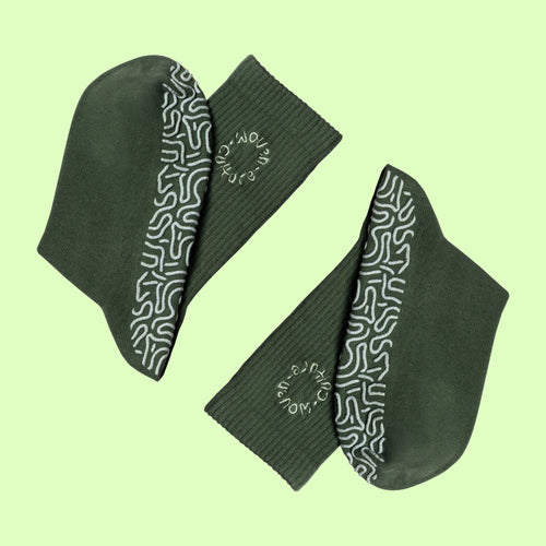 Green organic cotton grip socks with non-slip sole pattern and Woven Culture logo, eco-friendly Pilates and yoga socks.